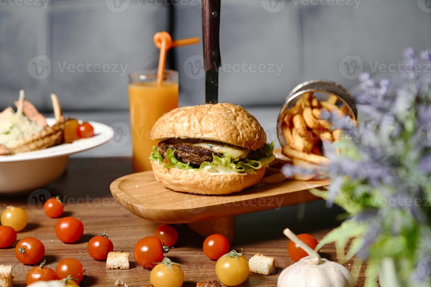 Juicy Burger and Crispy Fries on Wooden Table photo