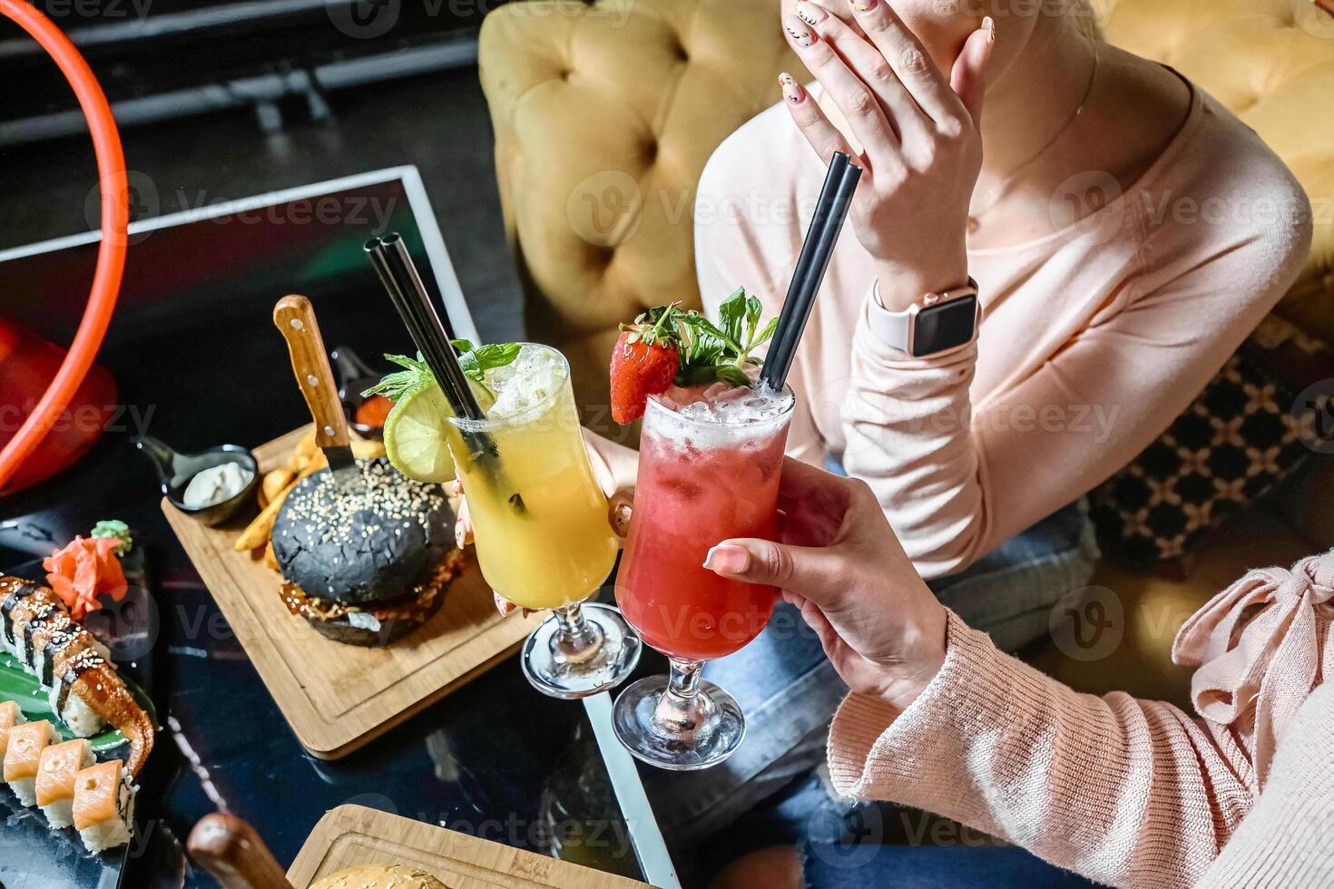 Woman Sitting at Table, Holding Drink photo