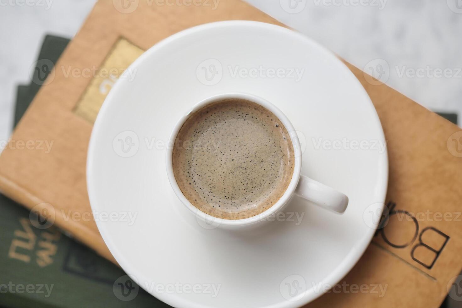 taza de café descansando en abierto libro foto