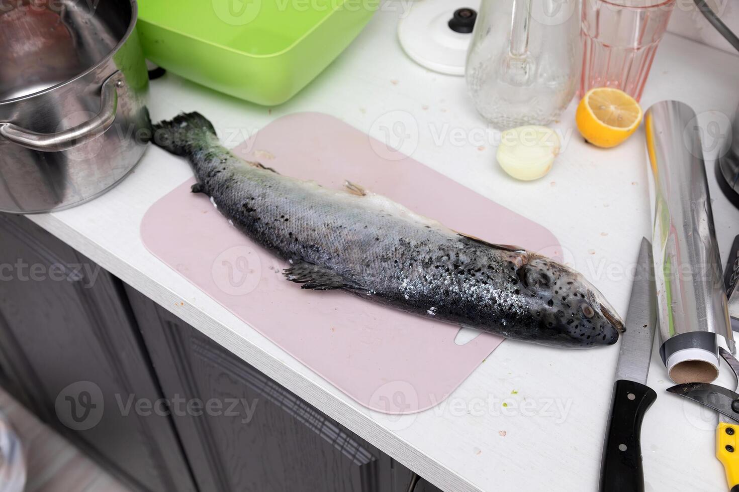 Fish and knife on a kitchen table photo