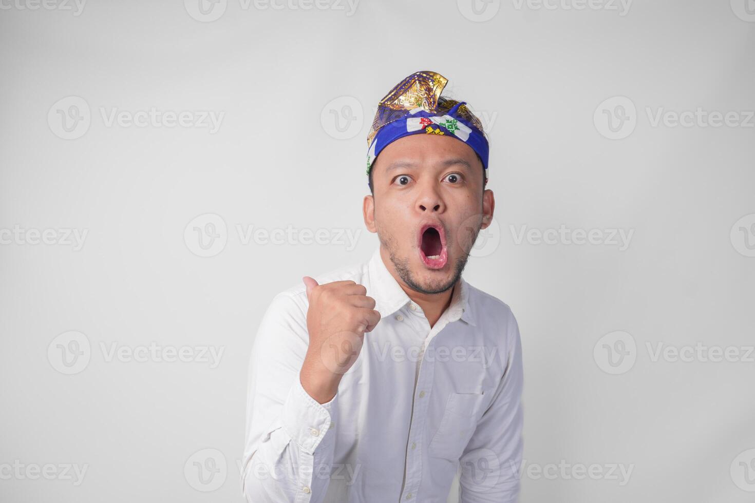 sorprendido balinés hombre en blanco camisa y tradicional tocado llamado udeng señalando a el Copiar espacio en el izquierda y Derecha lado foto