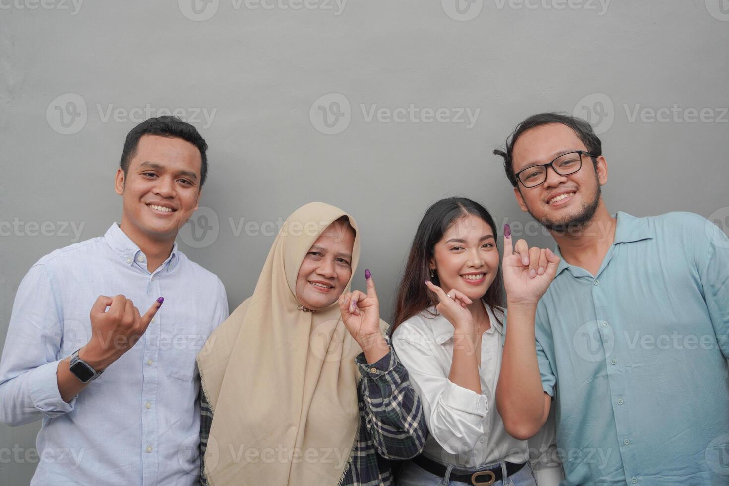 retrato de emocionado indonesio familia demostración el pequeño dedo sumergido en púrpura tinta después votación para general elección o pemilu para presidente y gobierno, aislado gris antecedentes foto