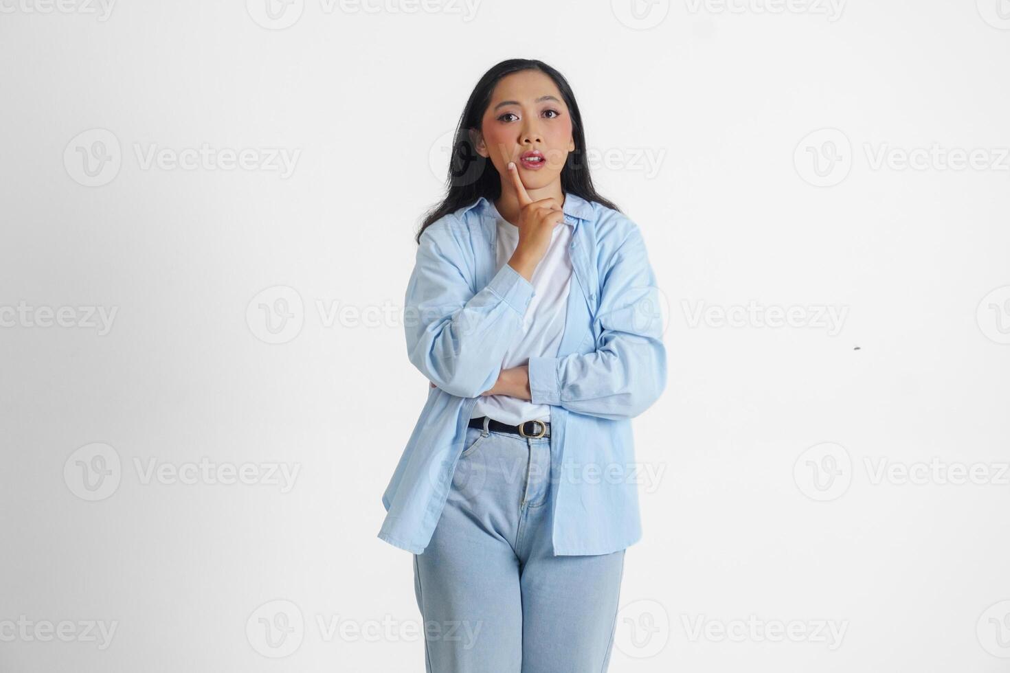 un pensativo asiático mujer vistiendo azul camisa es imaginando su pensamientos, aislado por blanco antecedentes. foto