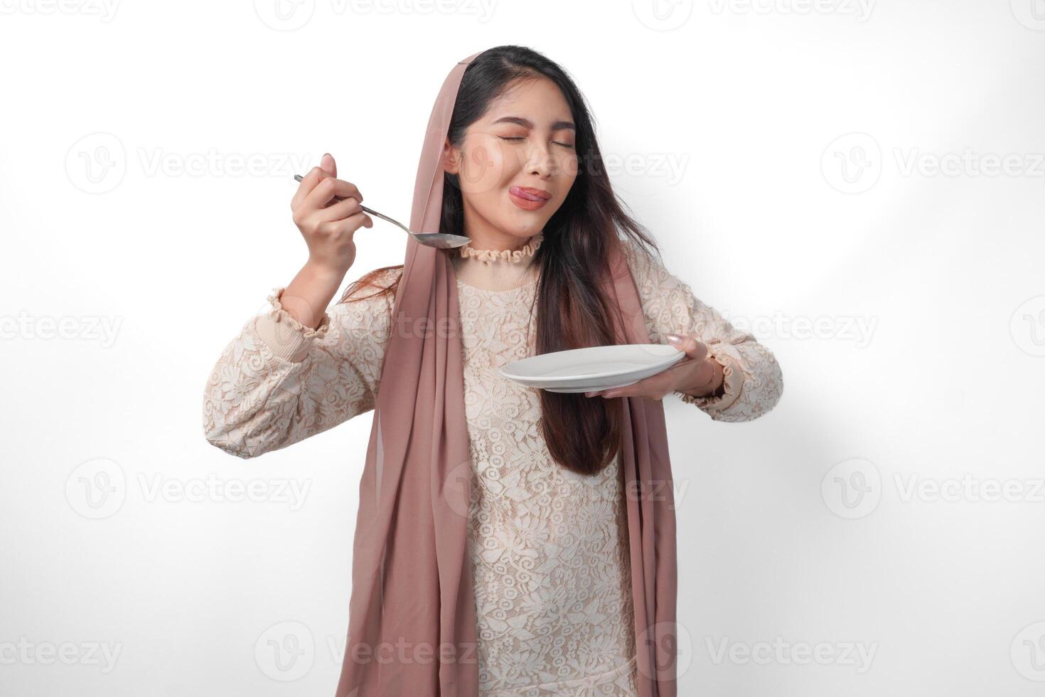 retrato de un hambriento asiático musulmán mujer participación cuchillería a comer o gusto delicioso platos en el Copiar espacio terminado el lámina, aislado blanco antecedentes foto