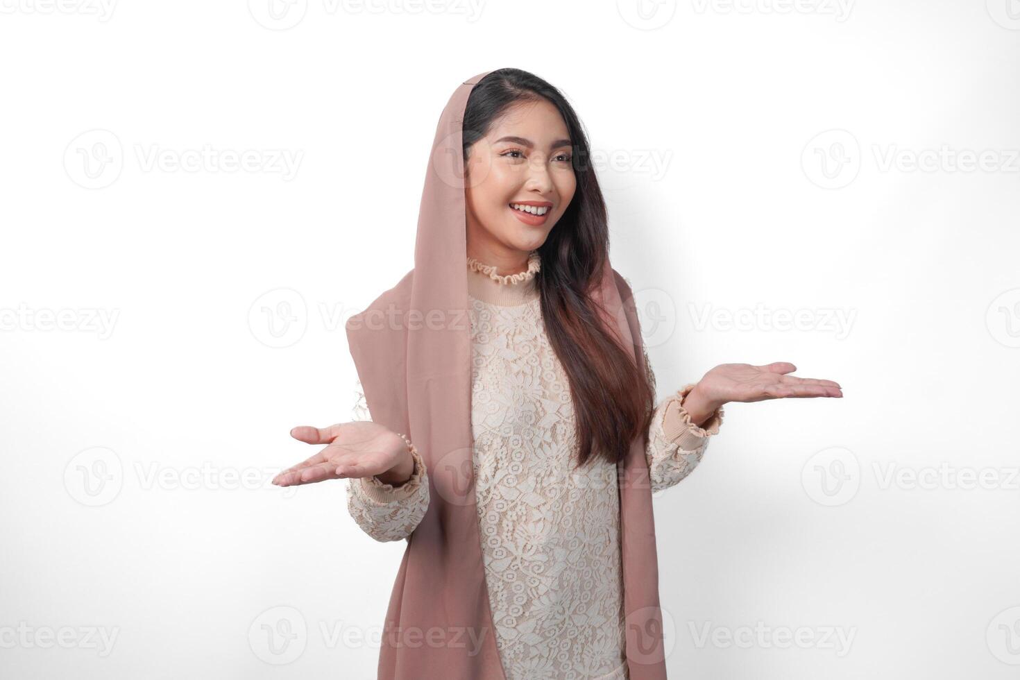 sonriente asiático musulmán mujer en Pañuelo velo hijab presentación Copiar espacio, en pie terminado aislado blanco antecedentes. Ramadán y eid Mubarak anuncio concepto foto