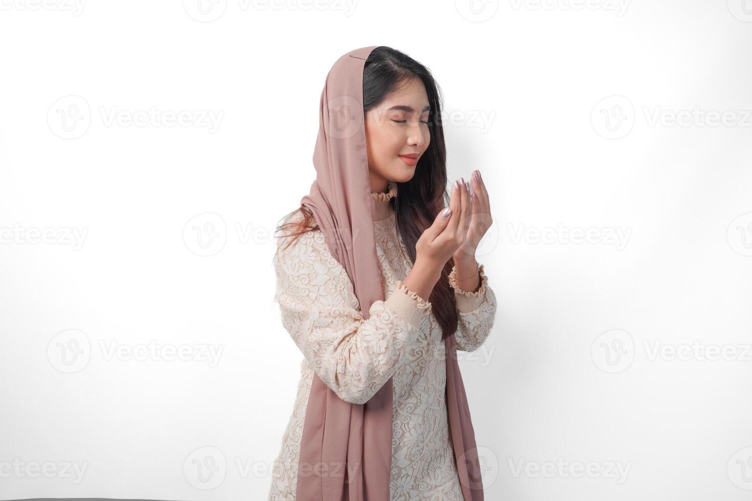 religioso asiático musulmán mujer vistiendo velo Pañuelo con manos en Orando gesto a dios, en pie terminado aislado blanco antecedentes. Ramadán y eid Alabama fitr concepto foto