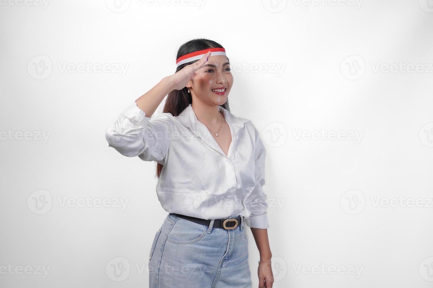 hermosa joven asiático mujer vistiendo casual atuendo y bandera venda gesticulando saludo gesto con Copiar espacio aislado en blanco antecedentes. indonesio independencia día concepto foto
