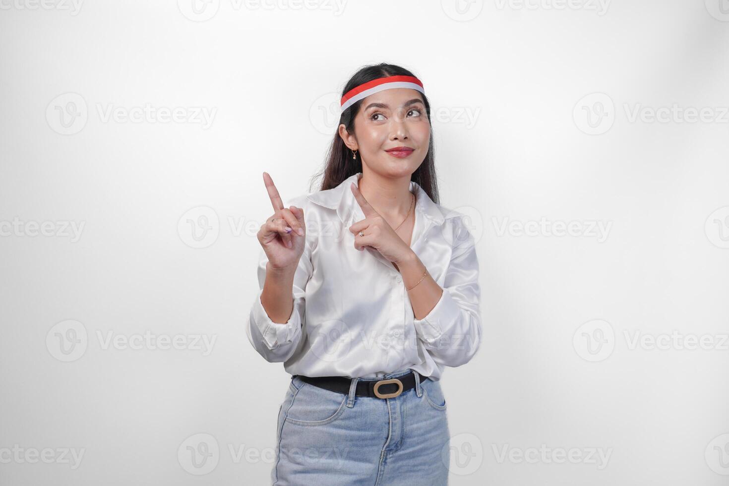 emocionado asiático mujer vistiendo bandera venda presentación y señalando a el Copiar espacio en el lado, sonriente amplio y en pie en aislado blanco antecedentes. independencia día anuncio concepto foto