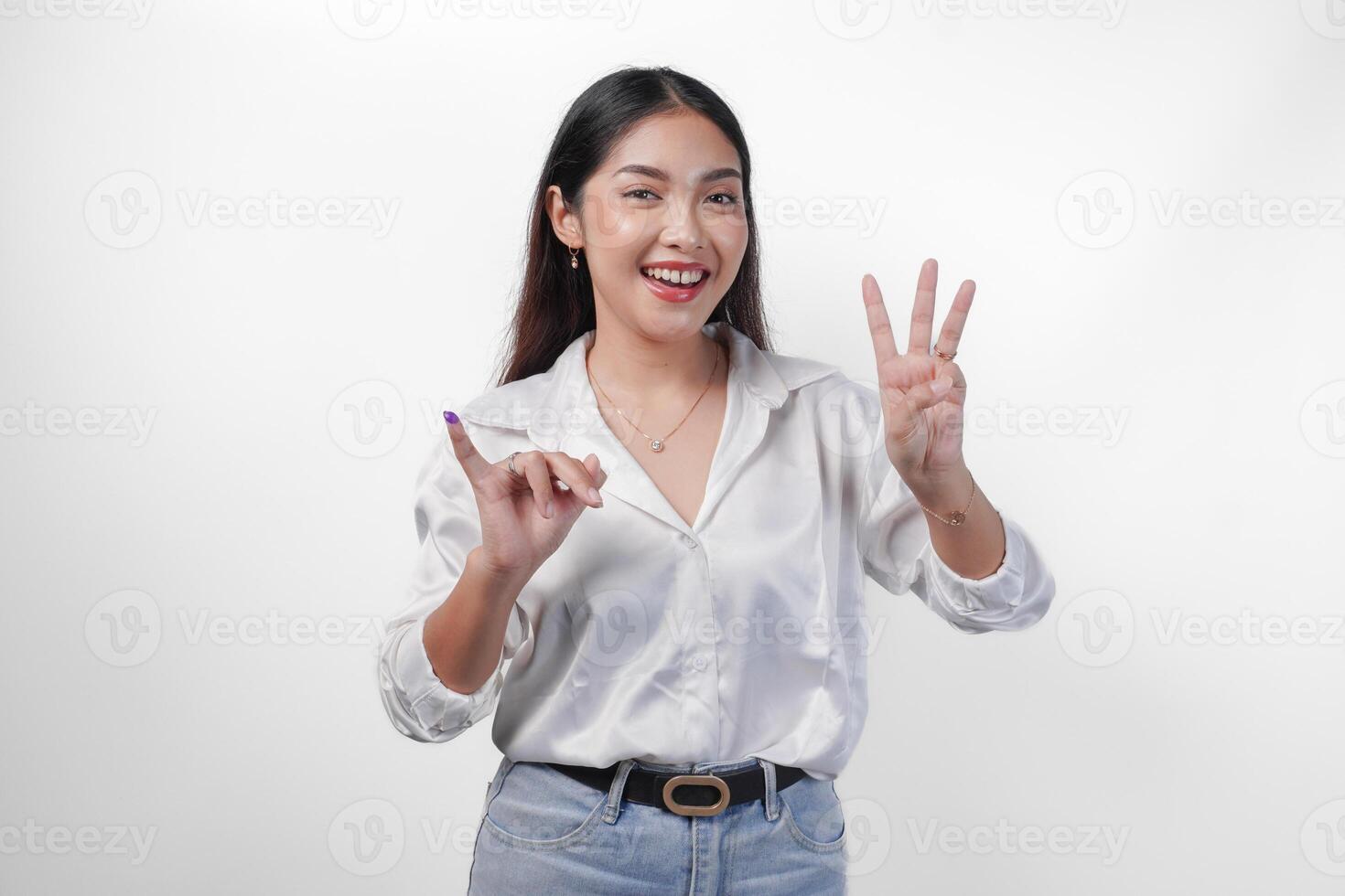 emocionado asiático joven mujer demostración pequeño dedo sumergido en púrpura tinta después votación para pemilu o Indonesia elección y señalando con dedos número uno dos tres, en pie en aislado blanco antecedentes foto