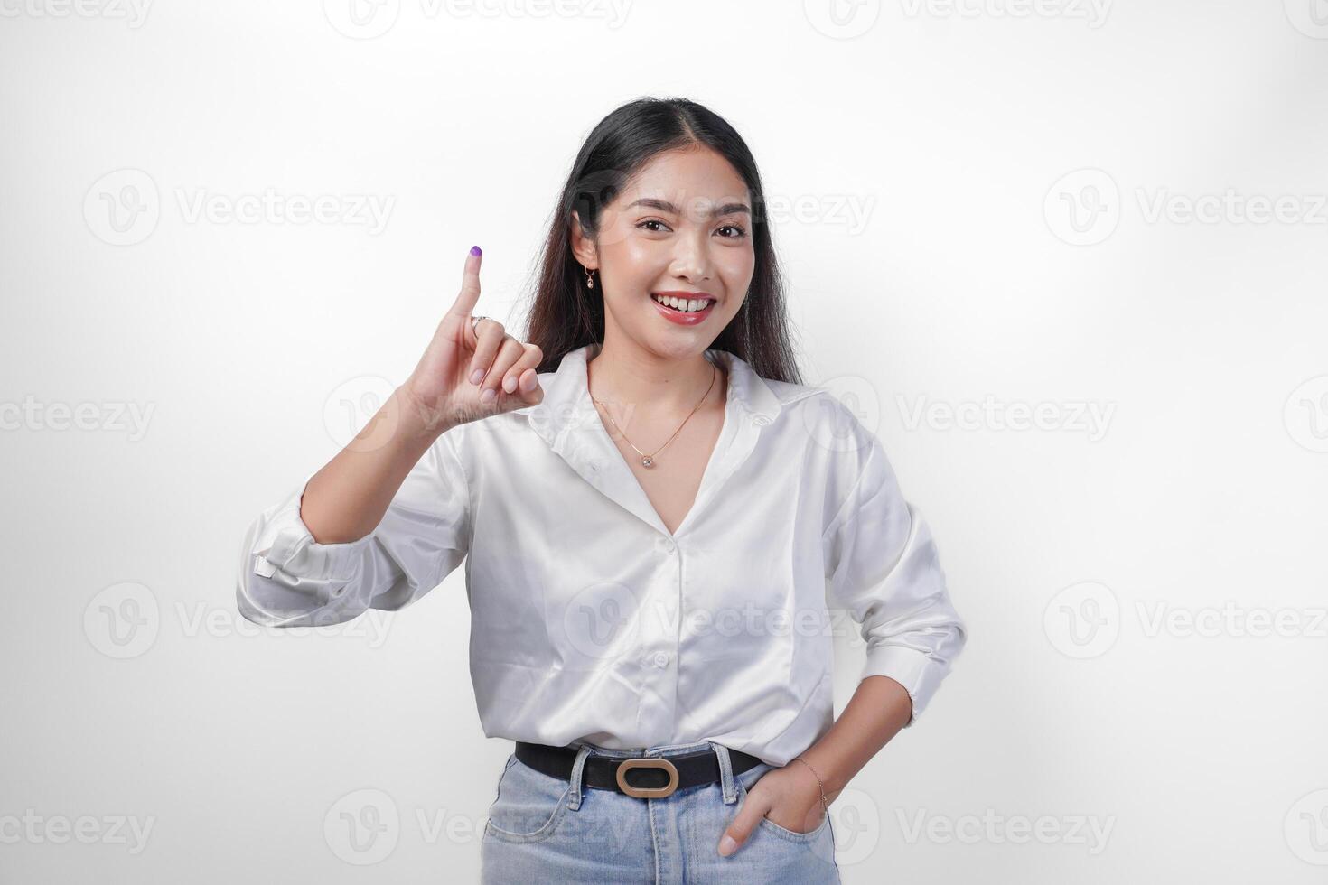 Young Asian woman proudly showing little finger dipped in purple ink after voting for president and parliament election, expressing excitement and happiness photo