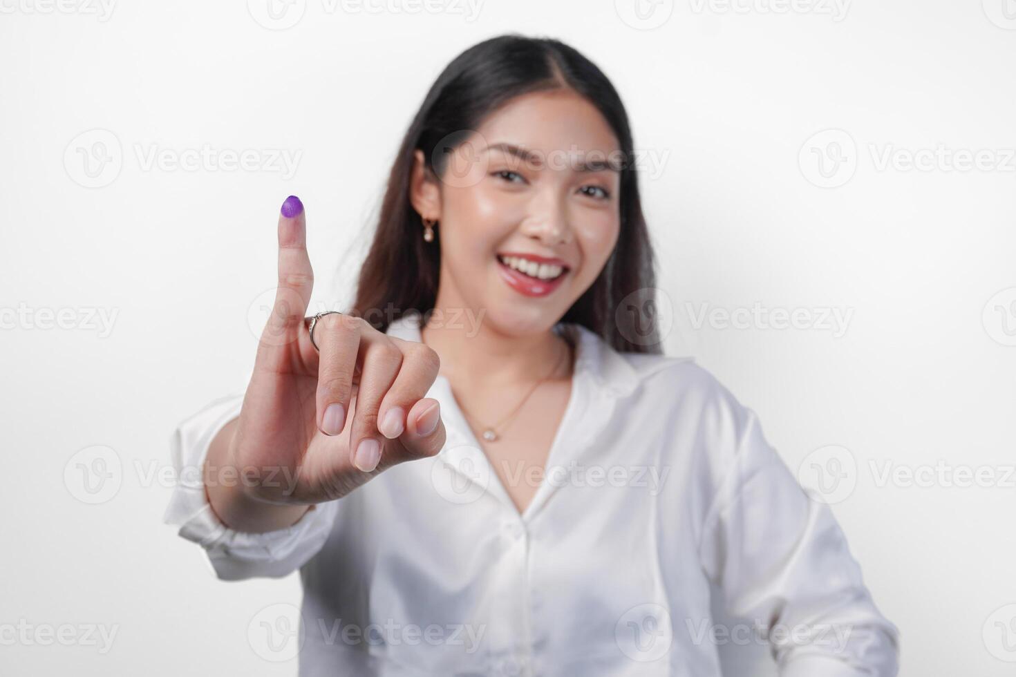 joven asiático mujer con orgullo demostración pequeño dedo sumergido en púrpura tinta después votación para presidente y parlamento elección, expresando emoción y felicidad foto