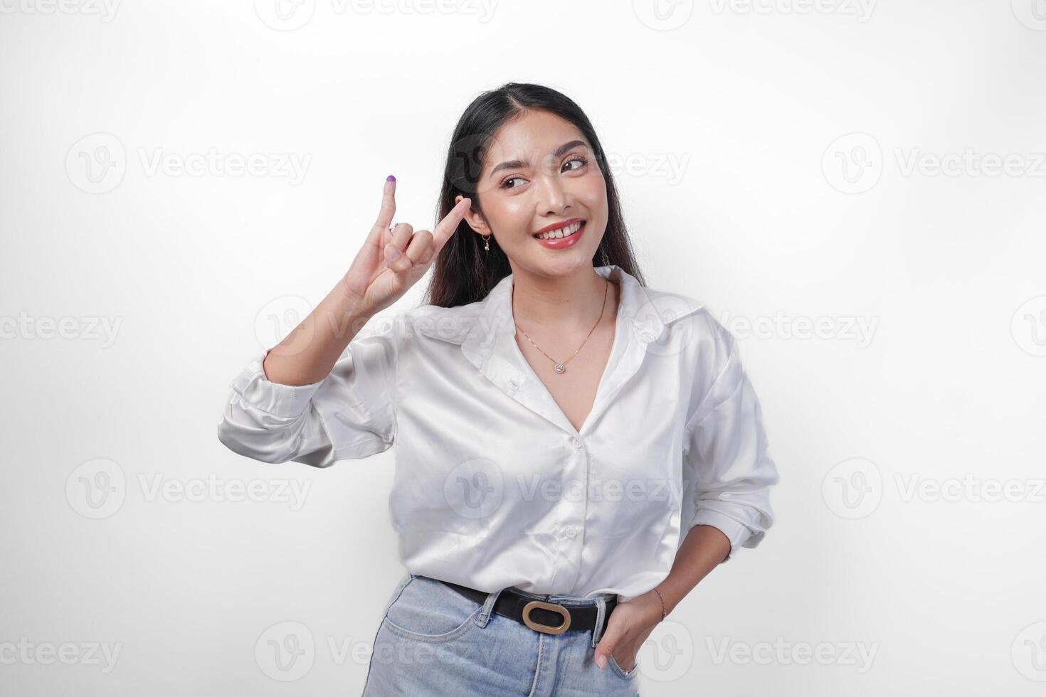 Excited Asian young woman showing little finger dipped in purple ink after voting for Pemilu or Indonesia election and pointing with fingers number one two three, standing on isolated white background photo