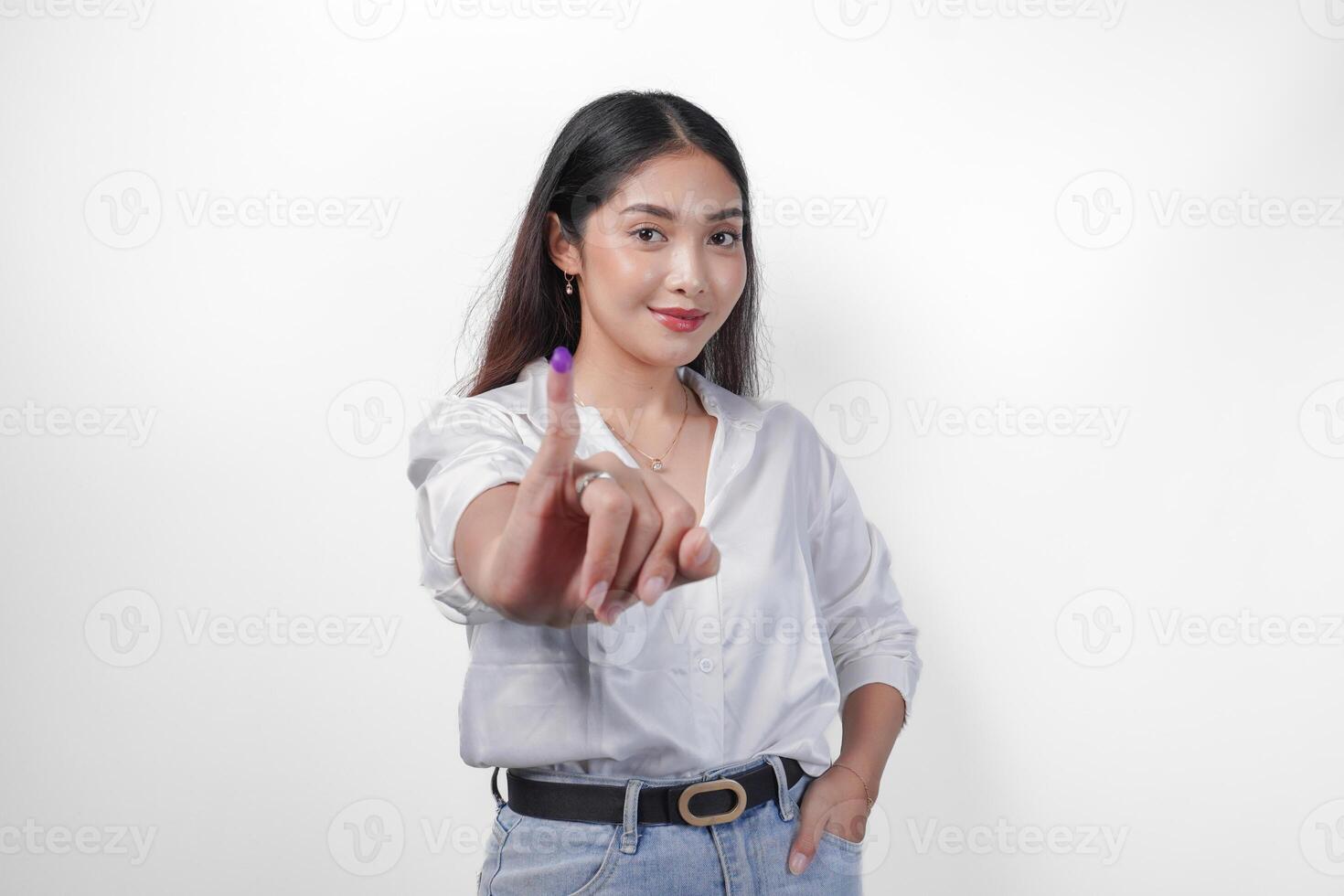 Young Asian woman proudly showing little finger dipped in purple ink after voting for president and parliament election, expressing excitement and happiness photo