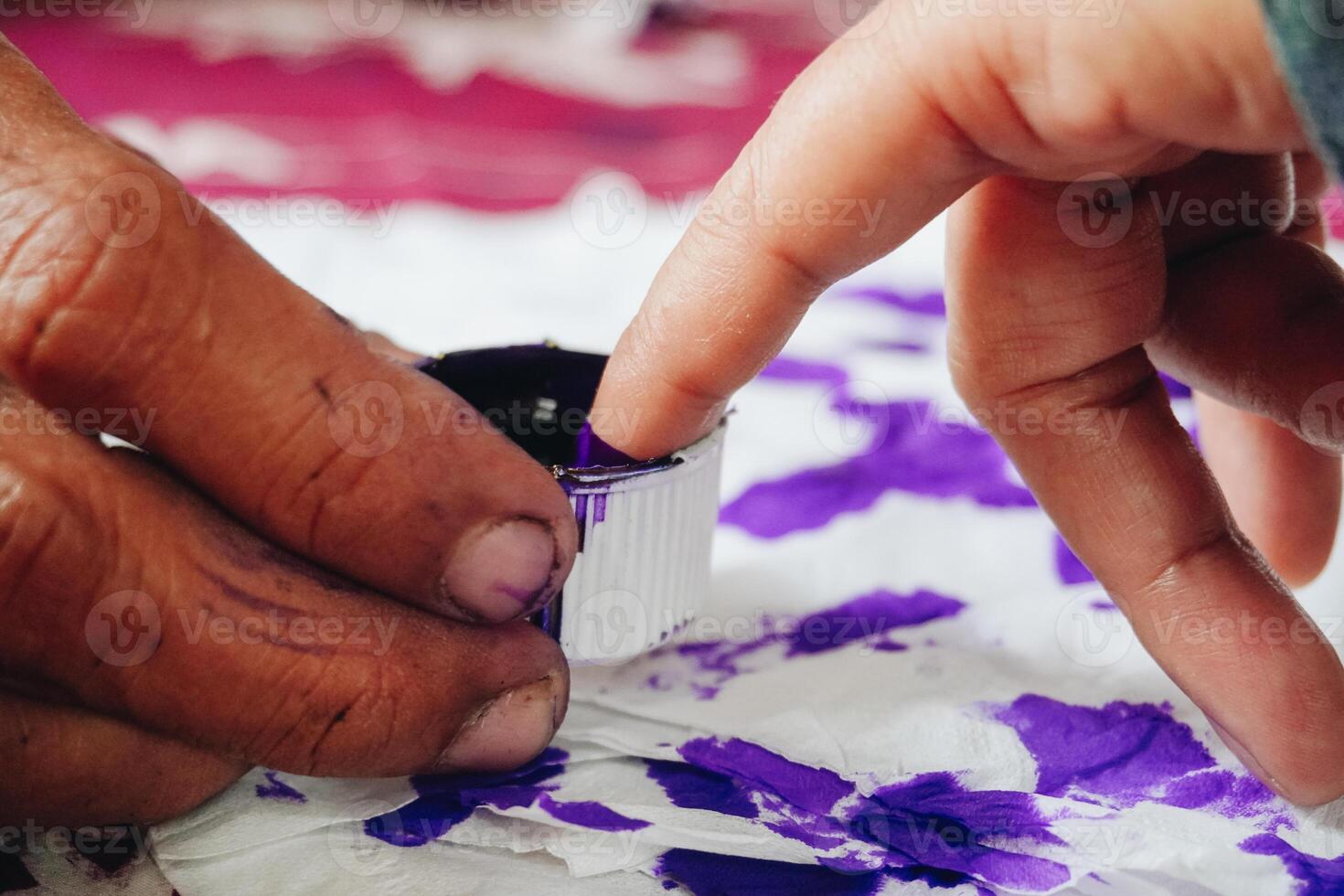 Close up portrait of little finger dipping into purple ink after voting for Indonesia President and Government Election 2024 photo