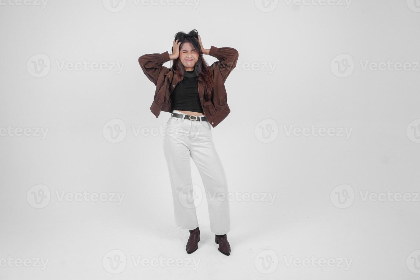 A sad Asian woman wearing a brown jacket looks stressed and depressed, isolated white background. photo