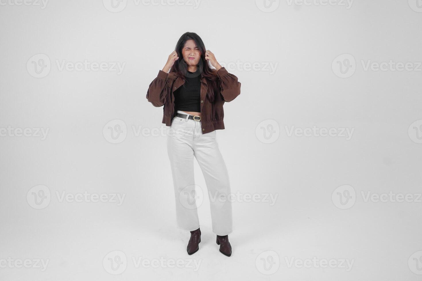 A sad Asian woman wearing a brown jacket looks stressed and depressed, isolated white background. photo