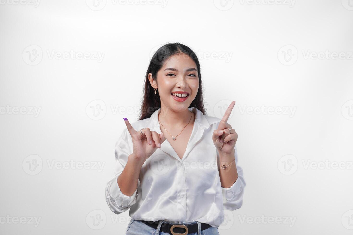 emocionado asiático joven mujer demostración pequeño dedo sumergido en púrpura tinta después votación para pemilu o Indonesia elección y señalando con dedos número uno dos tres, en pie en aislado blanco antecedentes foto