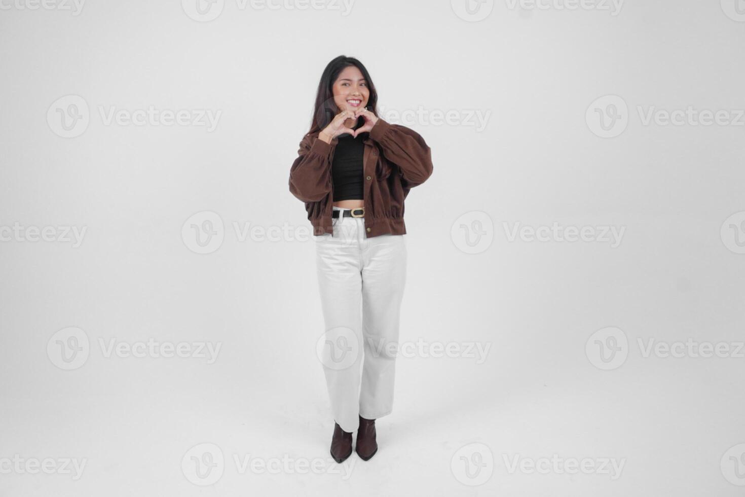 retrato lleno cuerpo de un joven asiático mujer haciendo amor corazón forma utilizando su manos en aislado blanco antecedentes foto