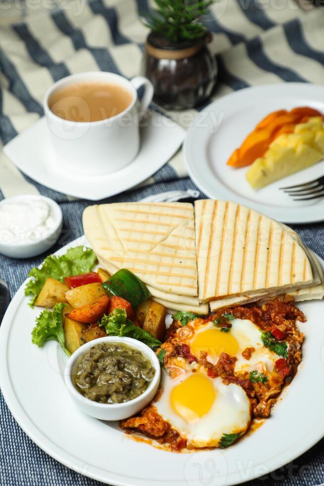 shakshouka con vegetal ensalada incluir tomate, papa, lechuga hoja y Zanahoria con té, café, y dulce melón servido en comida mesa parte superior ver sano desayuno foto