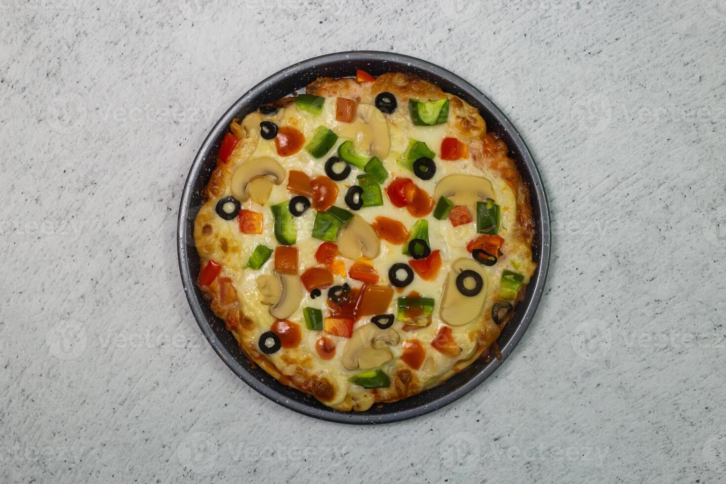 vegetable pizza topping with olives, tomato, onion, capsicum, mushroom and cheese served in dish isolated on grey background top view of bangladeshi fastfood photo