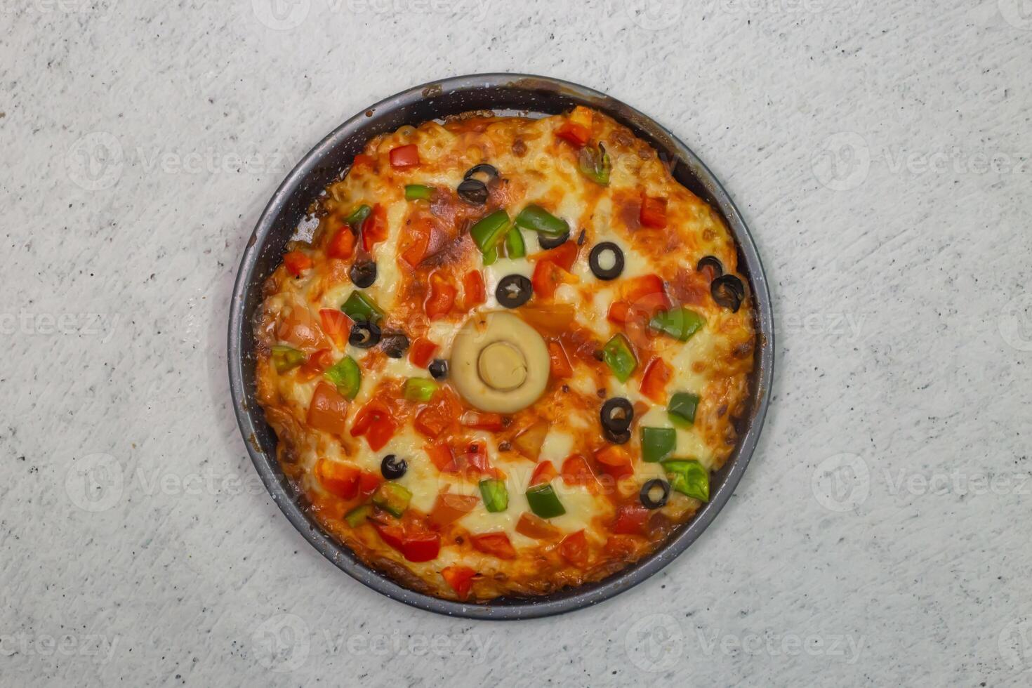 vegetable pizza topping with olives, tomato, onion, cucumber, mushroom and cheese served in dish isolated on grey background top view of bangladeshi fastfood photo