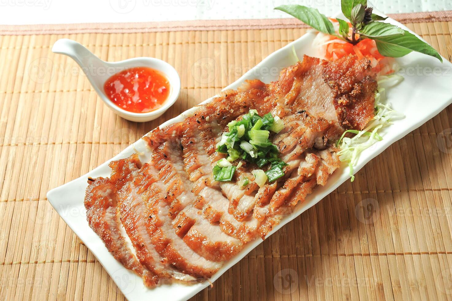 Lemongrass Pork Neck with chilli sauce served in dish isolated of table top view fast food snacks photo