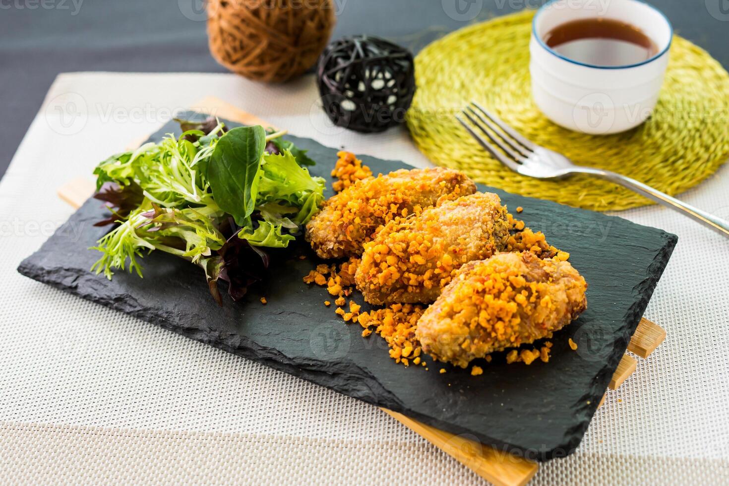 Typhoon Shelter Chicken Wing with Salad served on cutting board isolated on napkin side view of fastfood photo