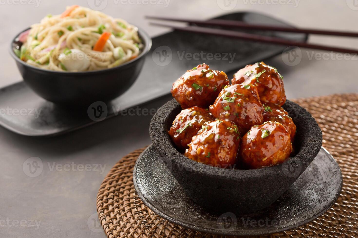 veg manchurian with hakka noodles and chopsticks served in bowl side view of chinese food photo