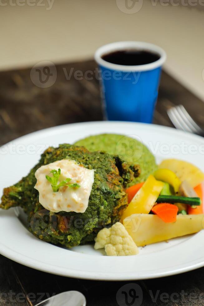 Garlic Chicken With Rice and Veg served in plate with cold drink, spoon and fork isolated on wooden board side view of thai food photo