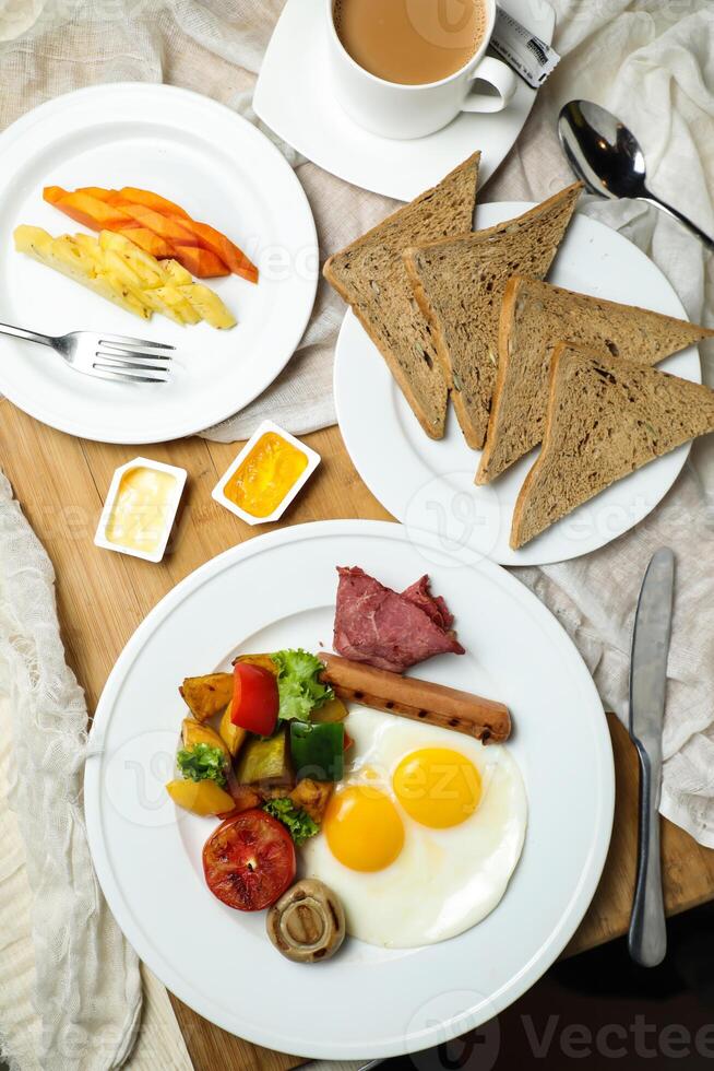 English breakfast with vegetable salad include tomato, potato, lettuce leaf and carrot with tea, coffee, and sweet melon served on food table top view healthy breakfast photo