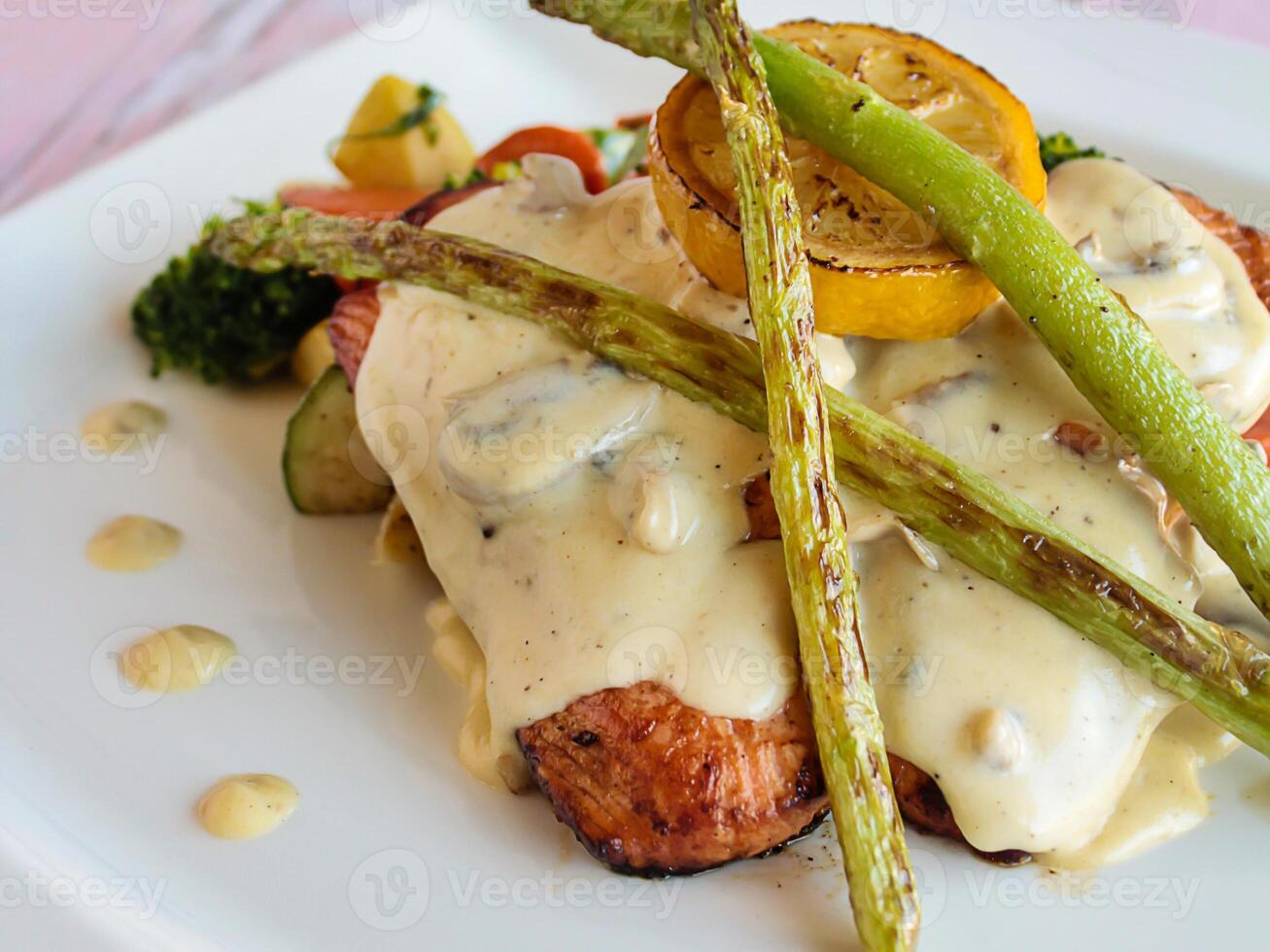 GRILLED SALMON Fish with mayo sauce and lemon slice served in dish isolated on table closeup top view of grilled seafood photo