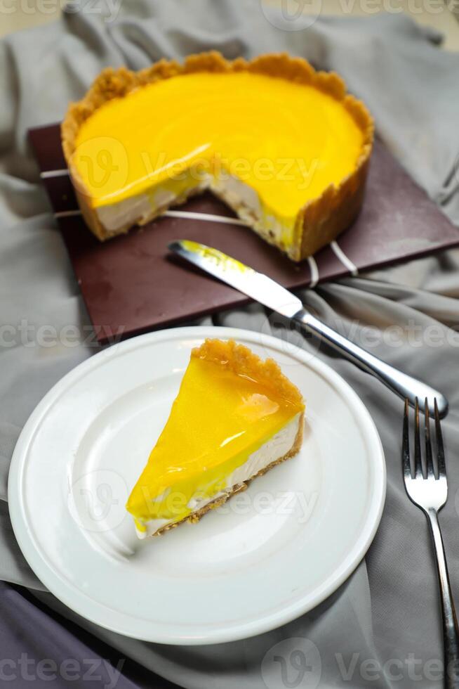 Fresh Lemon Cheesecake slice with fork and knife served in plate isolated on napkin top view cafe bake food photo