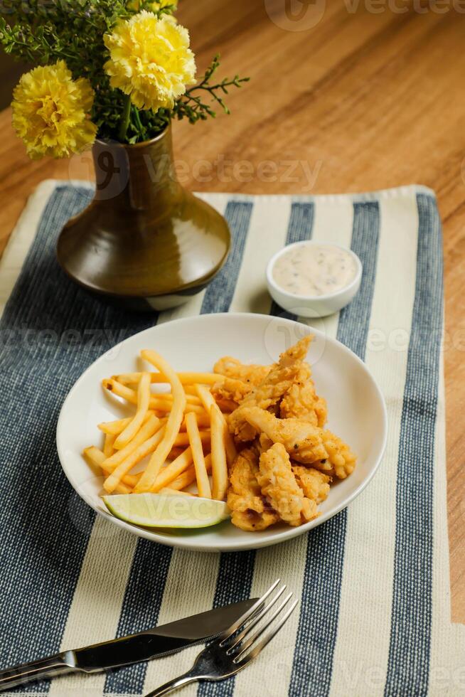 Deep Fried Garlic Mushroom with french fries, mayo dip, knife and fork served in dish isolated on table top view of fastfood appetizer photo