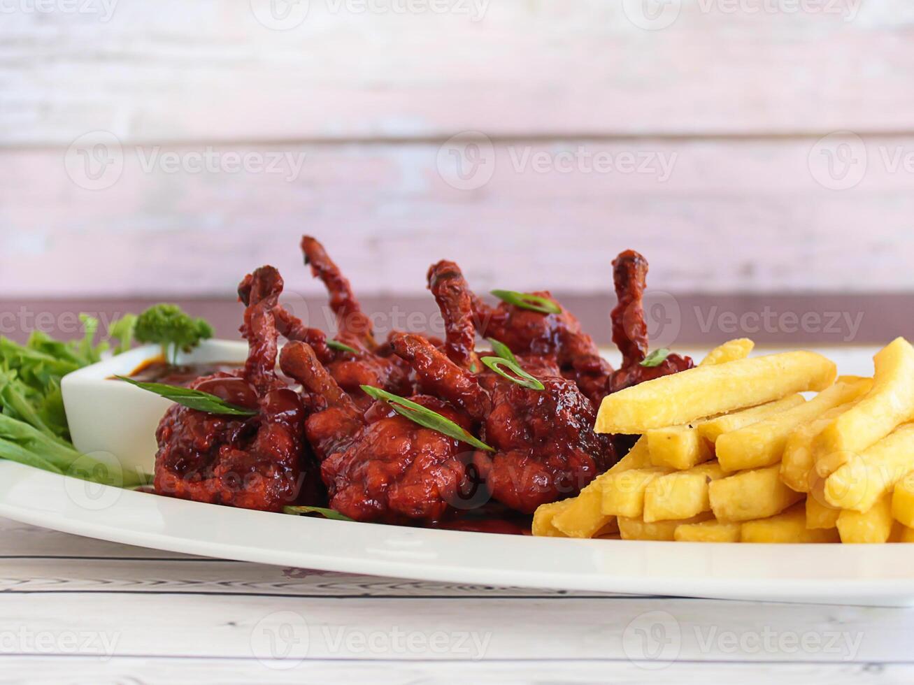 CHICKEN LOLLIPOP with French fries and Dip Sauce served in dish isolated on table side view of arabic fastfood photo