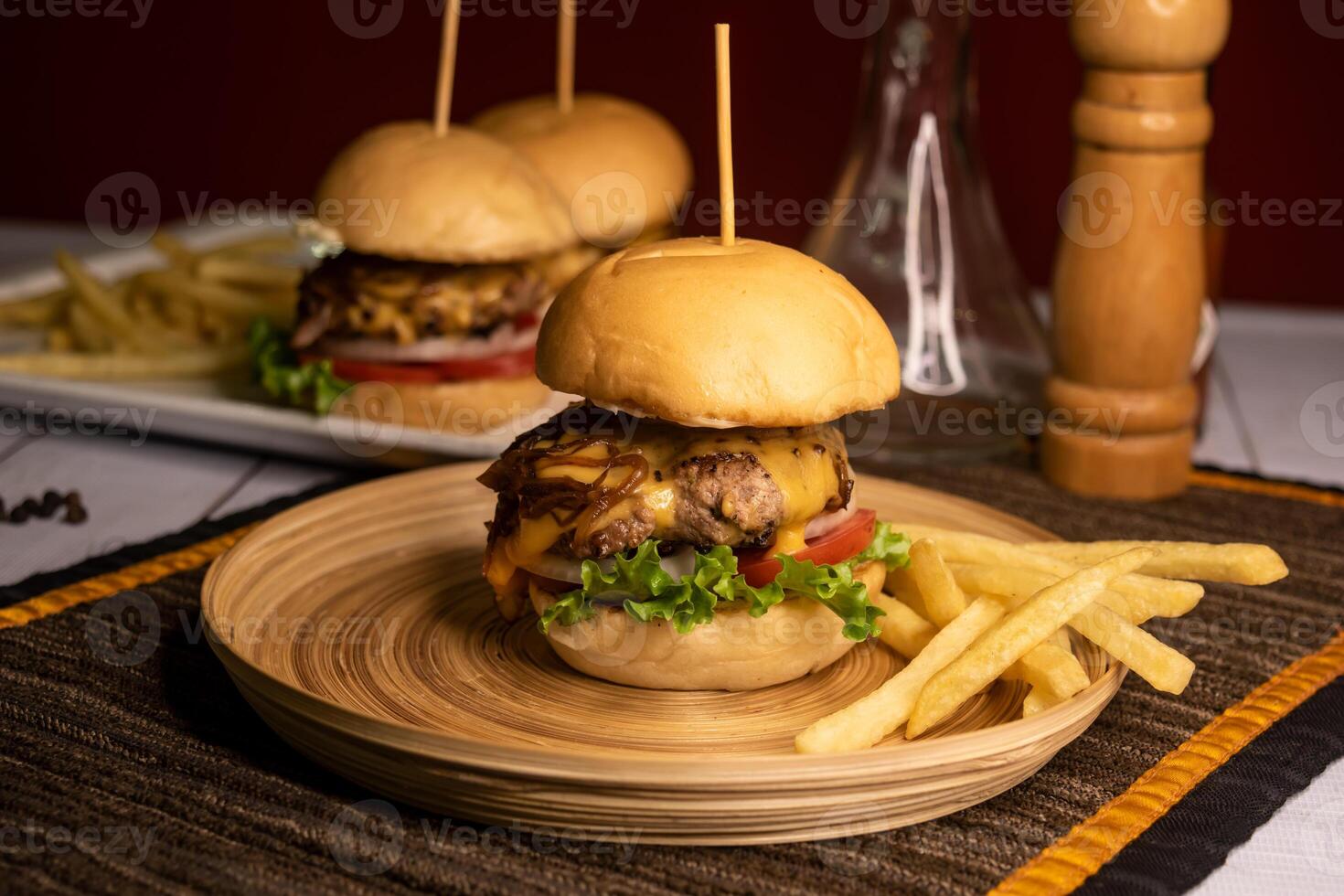 Beef Sliders include onion, tomato, lettuce leaf and french fries served in dish isolated on napkin side view on wooden table italian food photo