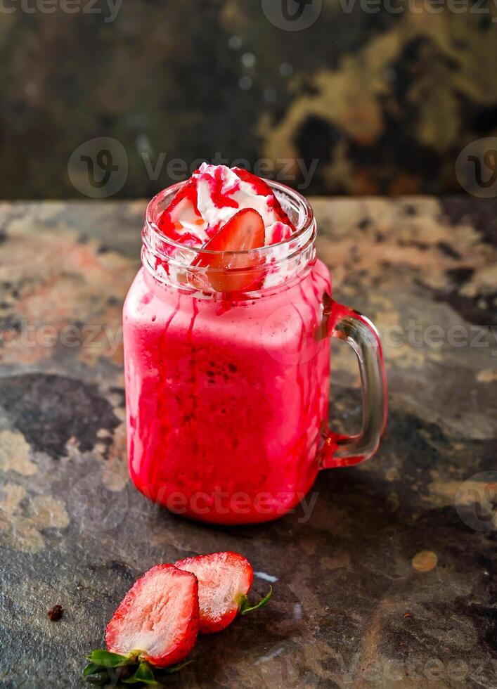 Strawberry Milkshake served in jar isolated on dark background side view of healthy drink photo