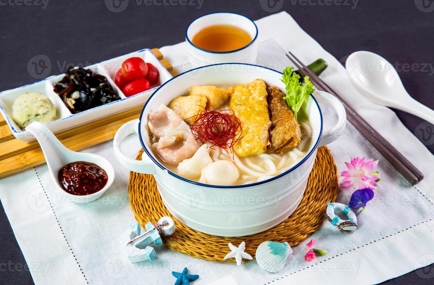 Rico pescado sopa pescado udon con chile salsa, inmersión y palillos servido en cuenco aislado en servilleta lado ver de japonés Mariscos en mesa foto
