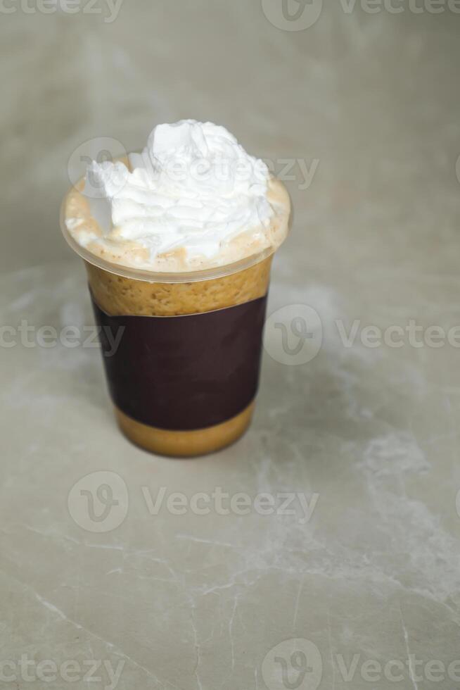 Iced Blended Hazelnut Latte coffee served in disposable cup isolated on grey background top view of cafe dessert photo