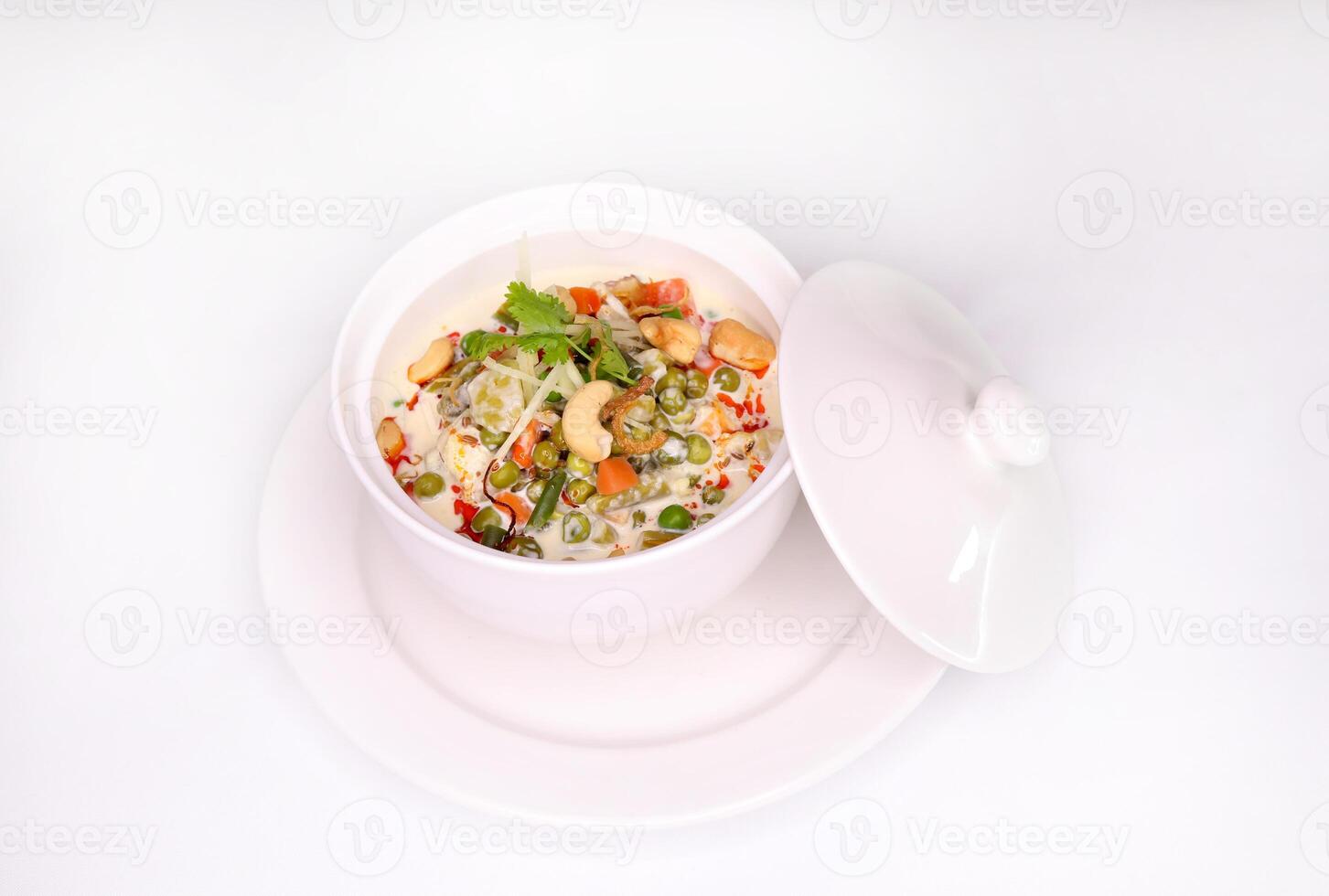 VEGETABLE KORMA with peas, tomato, bell pepper, potato and cashew nut served in dish isolated on background side view of arab food photo