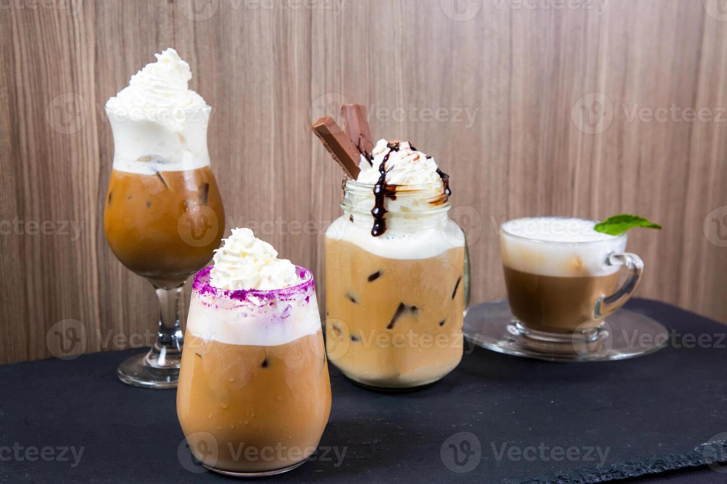 Assortment of specialty cold creamy coffee with chocolate served in jar isolated on table side view of cold dessert beverage on table photo