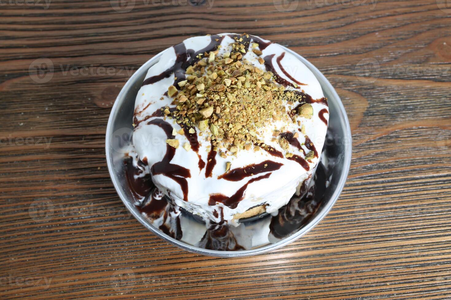 Arábica dulzura bomba con chocolate, hielo crema y pistacho Adición servido en plato aislado en mesa parte superior ver de Arábica postre comida foto