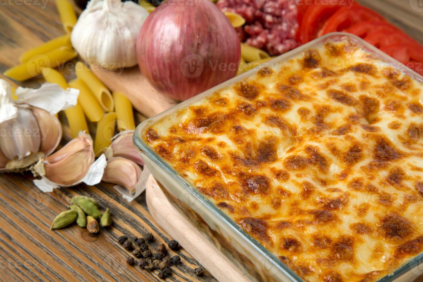 Pasta bechamel oven baked served in dish with minced meat, tomato, garlic, onion, black pepper and cardamom isolated on table side view of arabic food photo