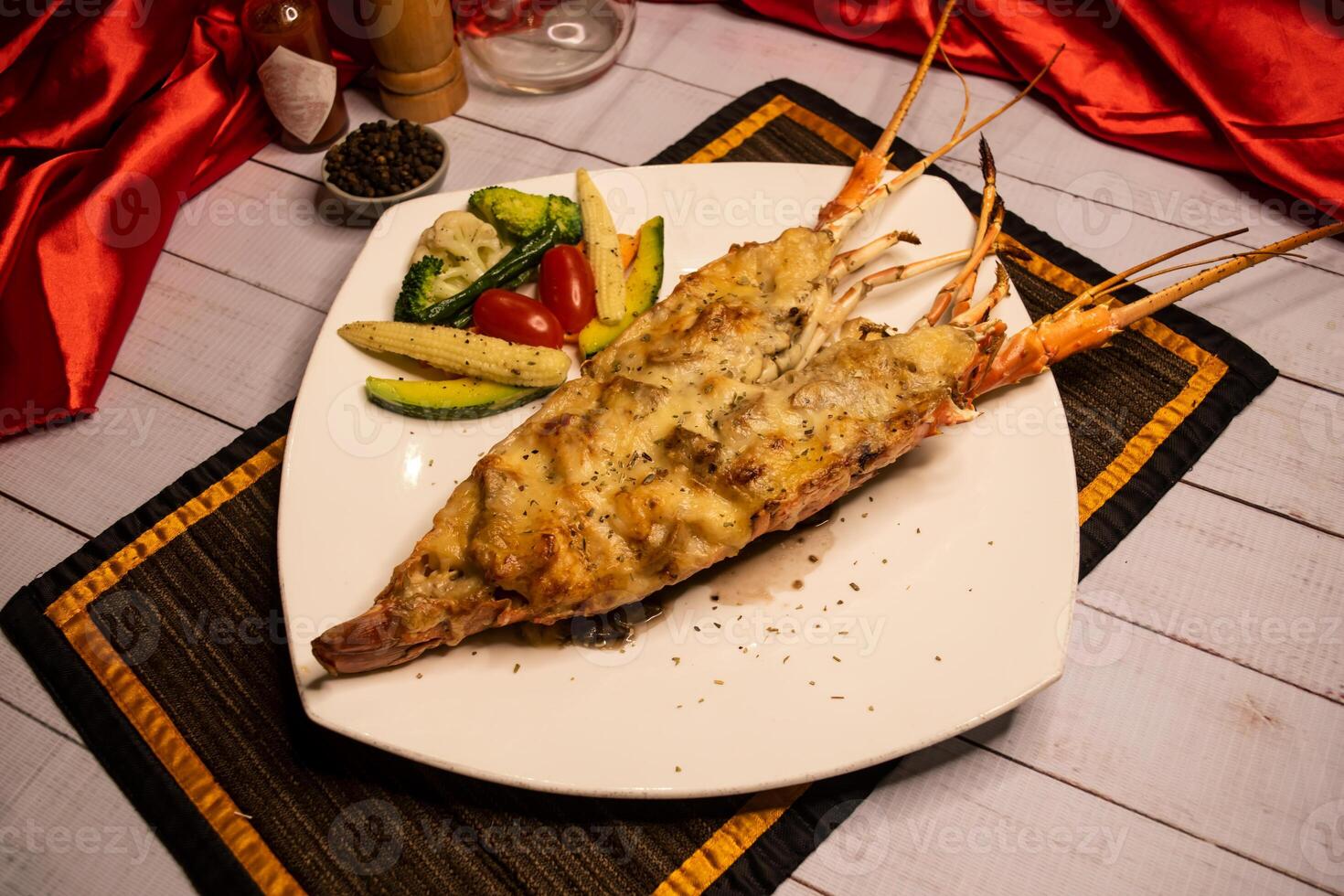 Whole Lobster Thermidor lobster cream sauce with salad, chilli sauce and black pepper served in dish isolated on napkin top view on wooden table italian food photo