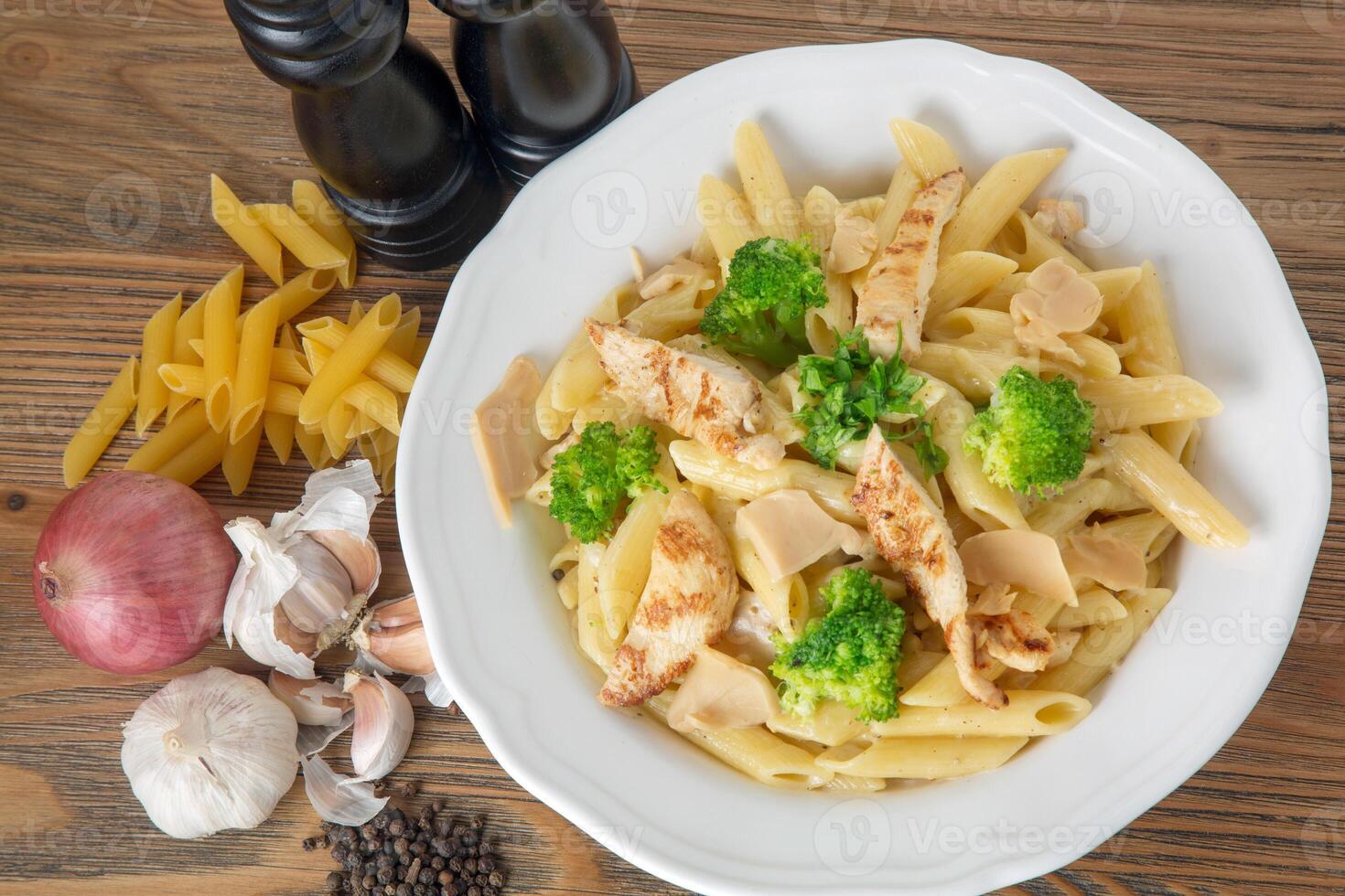 blanco salsa pasta con A la parrilla pollo, negro pimienta, ajo y cebolla servido en plato aislado en mesa parte superior ver de Arábica comida foto