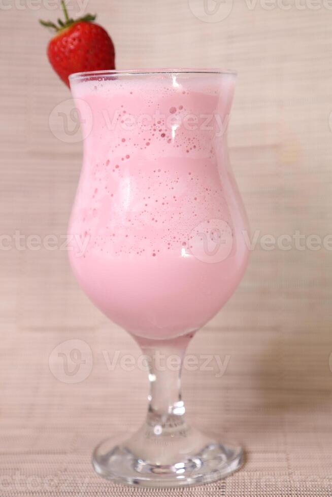 fresa malteada con crudo fresa y Paja servido en vaso aislado en gris antecedentes lado ver de sano Mañana Arábica bebida foto