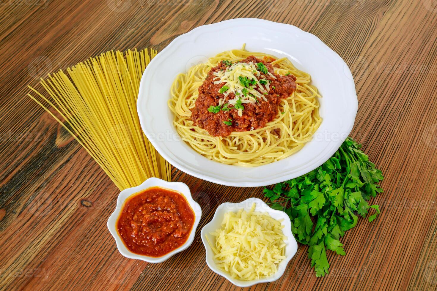 Spaghetti bolognese pasta with chili sauce paste and coriander served in dish isolated on table top view of arabic food photo