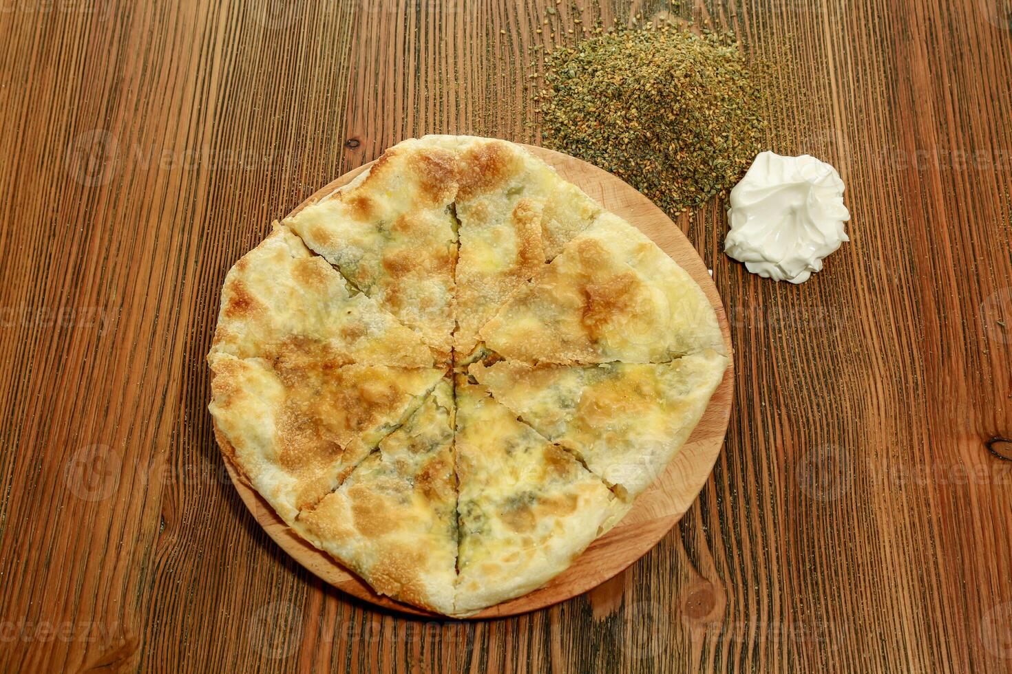 Labneh and thyme pie served in wooden board isolated on table top view of arabic food photo