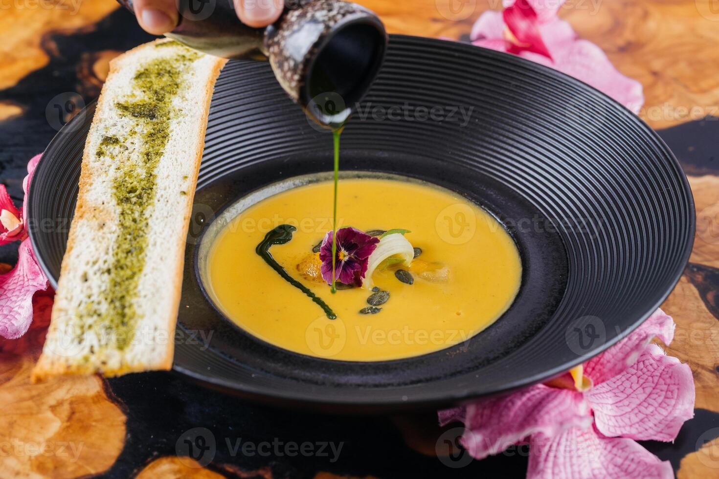 Roasted Pumpkin Soup with toast bread served in bowl isolated on table top view of arabic hot soup photo