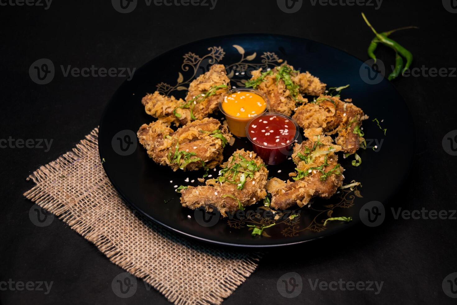 Crispy Chicken Wings with chilli sauce and mayo dip served in dish isolated on napkin dark background top view of indian fastfood photo
