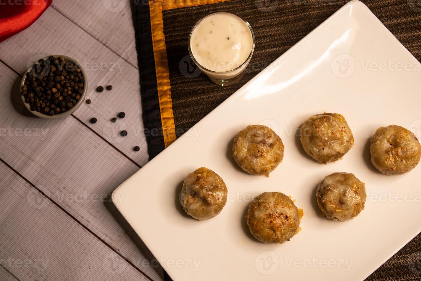 Stuffed Mushroom with shrimp meat balls dumplings with dip, black pepper and garlic chilli sauce served in dish isolated on napkin closeup top view on wooden table italian dim sum food photo